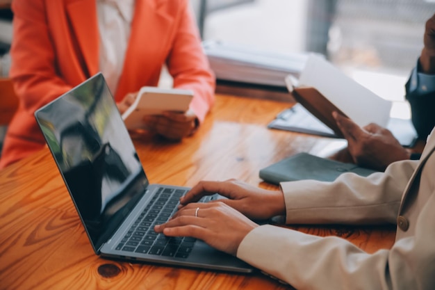 Two people at a table with laptops discussing a client portal interface