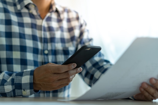 A smartphone being used to scan a paper document on a desk
