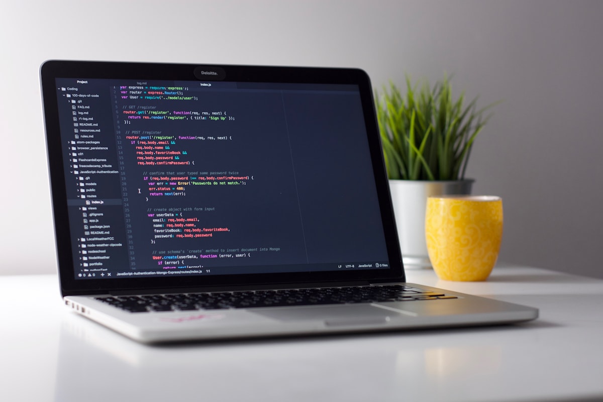 Laptop screen showing a web application being built with clean modern code