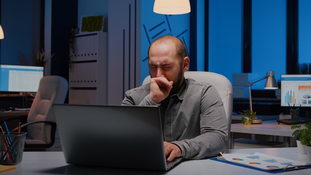 An office worker at a laptop surrounded by multiple application windows