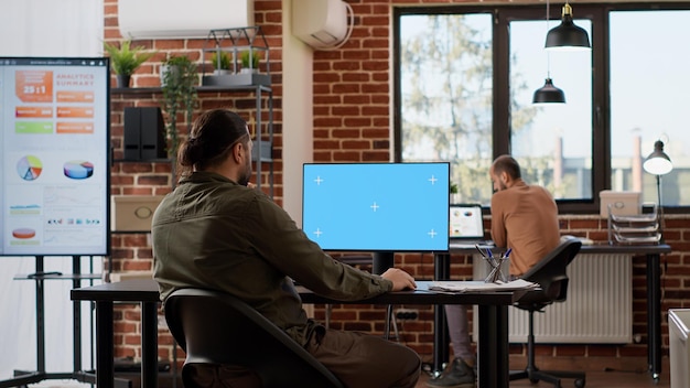 A professional working at a large monitor displaying an internal admin dashboard