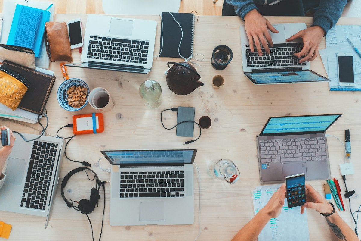 A team collaborating around a table with laptops, representing different approaches to software development
