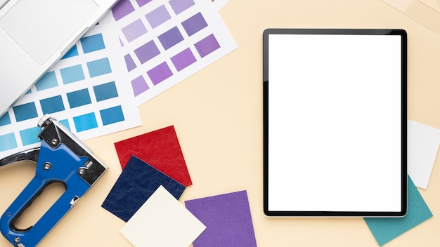 A thick printed manual on a desk next to a tablet showing the app version